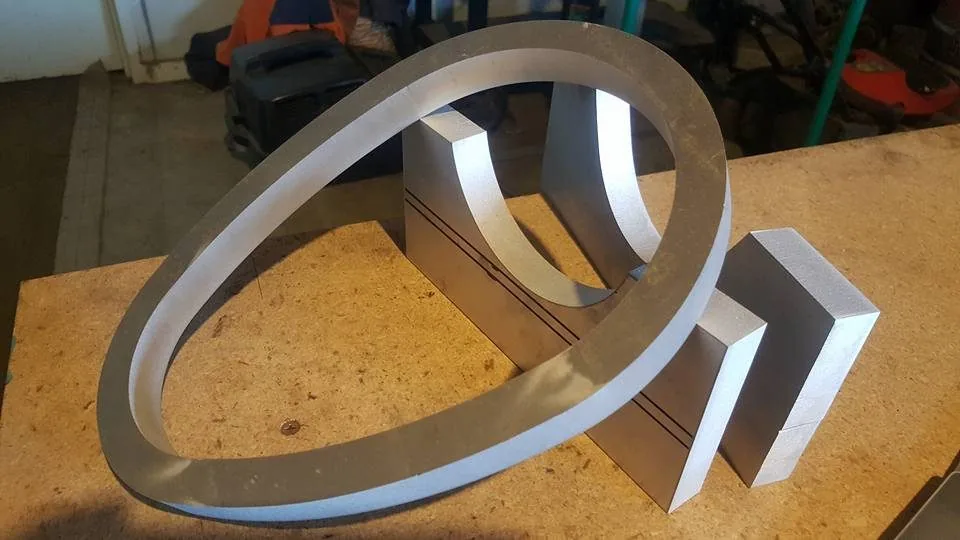 Stainless art piece shaped as the number six with an oval ring